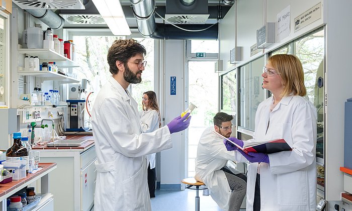 Dr. Guillaume Médard vom Lehrstuhl fuer Proteomik und Bioanalytik im Labor mit seiner Forschungsgruppe bei einer Besprechung.