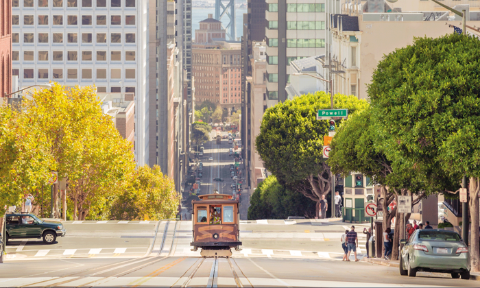 Classic view of historic traditional Cable Car riding on famous California Street in beautiful evening light at sunset in summer