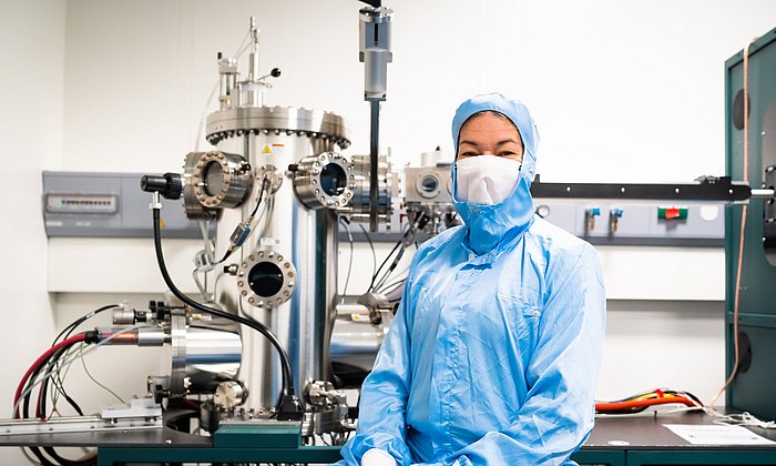 Eva Weig in front of the machine used to evaporate different metallic layers onto the chips via vapor deposition under ultrahigh vacuum. 