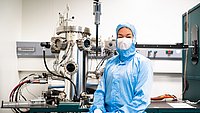 Die Professorin Eva Weig vor der Apparatur zum Aufdampfen der verschiedenen metallischen Schichten auf die Chips.