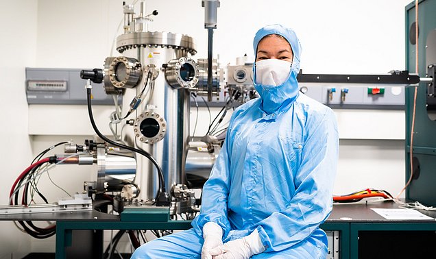 Die Professorin Eva Weig vor der Apparatur zum Aufdampfen der verschiedenen metallischen Schichten auf die Chips.