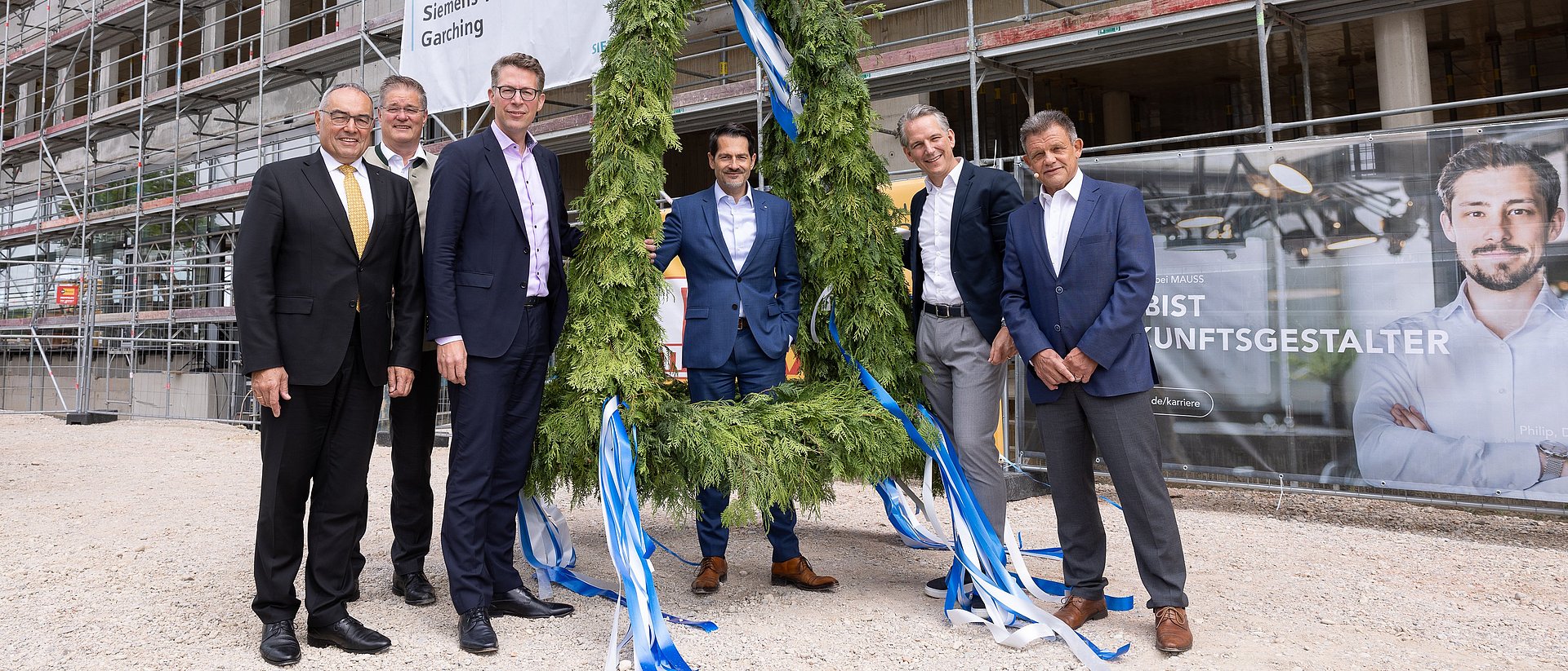 President Thomas F. Hofmann (middle), Chancellor Albert Berger (l.), State Minister Markus Blume (3.f.l.), Dr. Peter Körte and Dr. Zsolt Sluitner from Siemens (r.), and Garching mayor Dr. Dieter Gruchmann (2.f.l.) at the topping-out wreath for the Siemens Technology Center. 