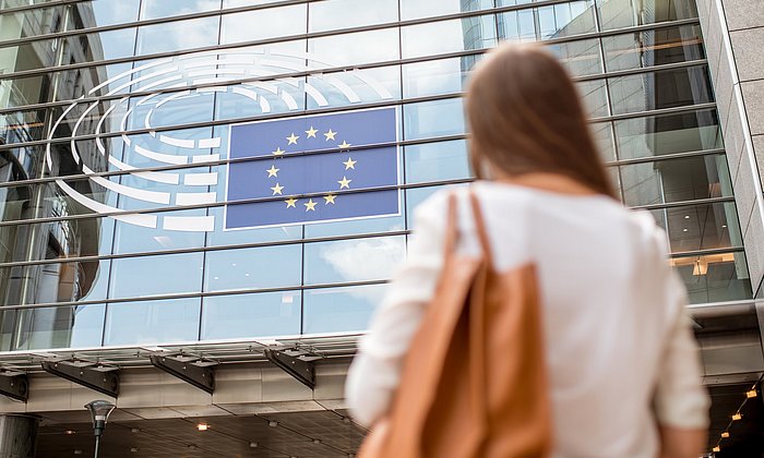 A woman infront of the European Parliament