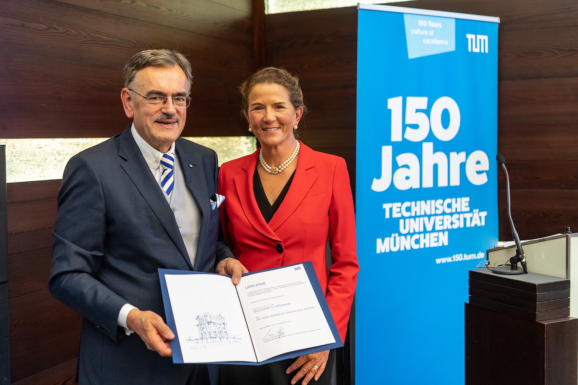 Susanne Wamsler, Mitglied des Verwaltungsrats von Clariant, überreicht Prof. Dr. Wolfgang A. Herrmann, Präsident der TUM, den Dr. Karl Wamsler Innovation Award, den Clariant und TUM vergeben.