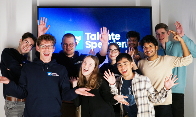 Eine Gruppe Studierender vor dem Logo von Talente Spenden e.V.