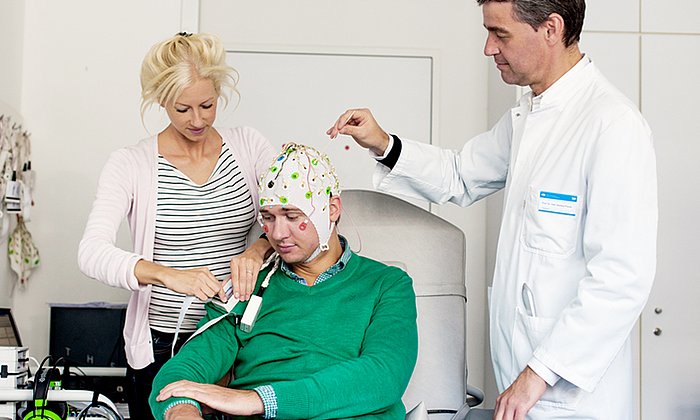 Markus Ploner (rechts) bereitet mit seiner Mitarbeiterin eine EEG-Aufnahme vor.