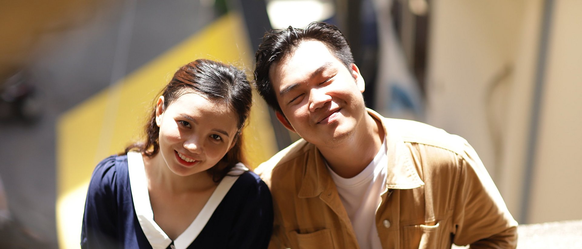 Zwei asiatischstämmige Studierende lächeln den Betrachter an.