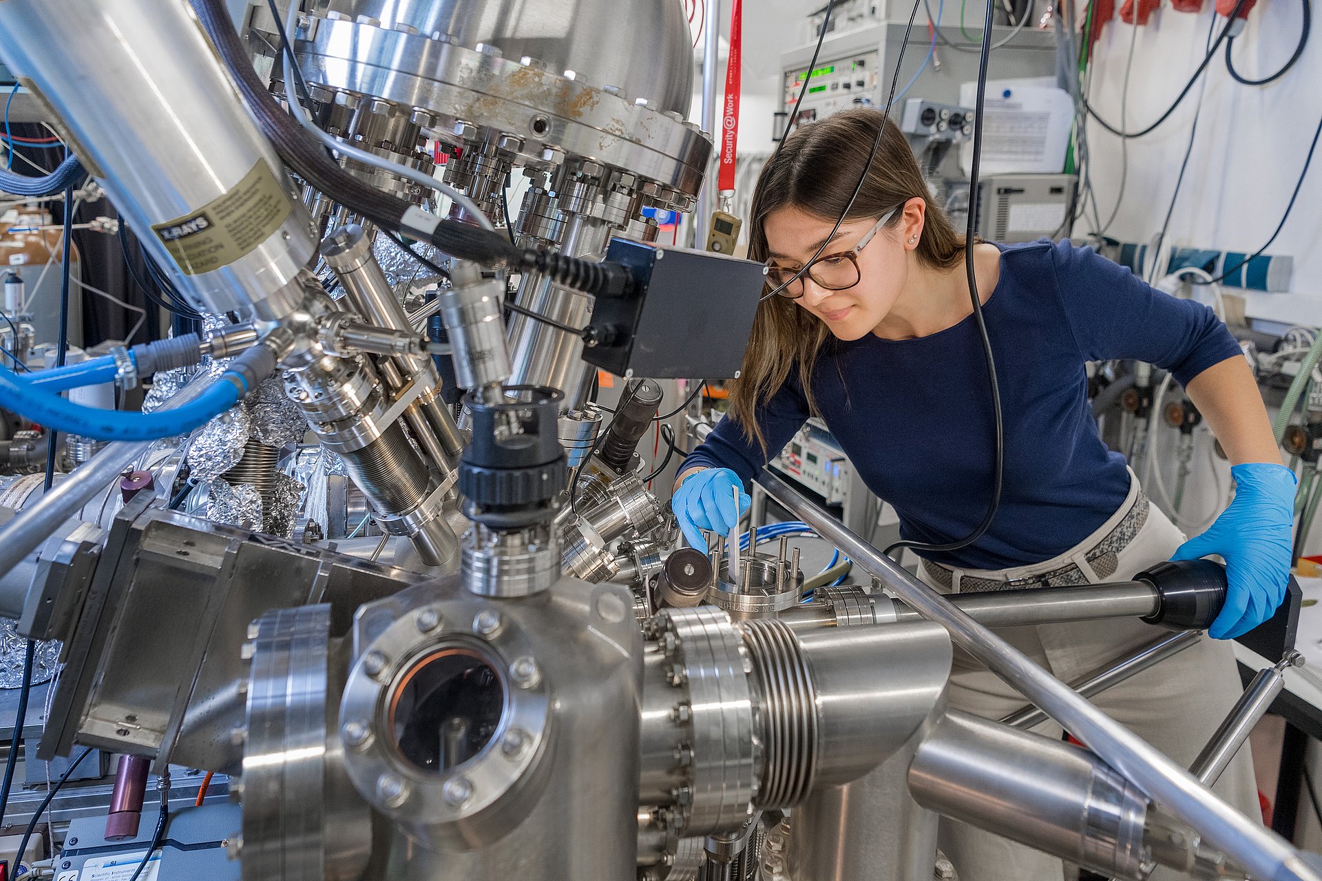 Nereida Abad-Yang loads a new sample into the load lock to later examine it in the microscope.