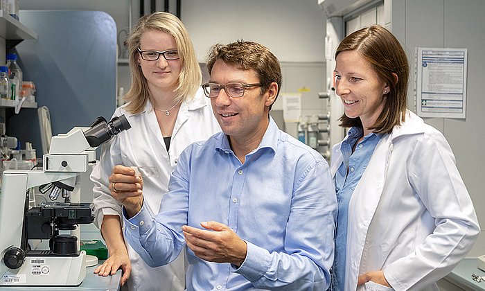 Prof. Dirk Haller analyzing tissue sections together with the scientists Sandra Bierwirth (left) and Olivia Coleman. (Image: A. Heddergott/ TUM)