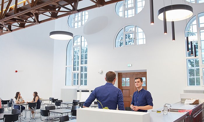 Students chat and work together in the foyer of one of the StudiTUM houses.