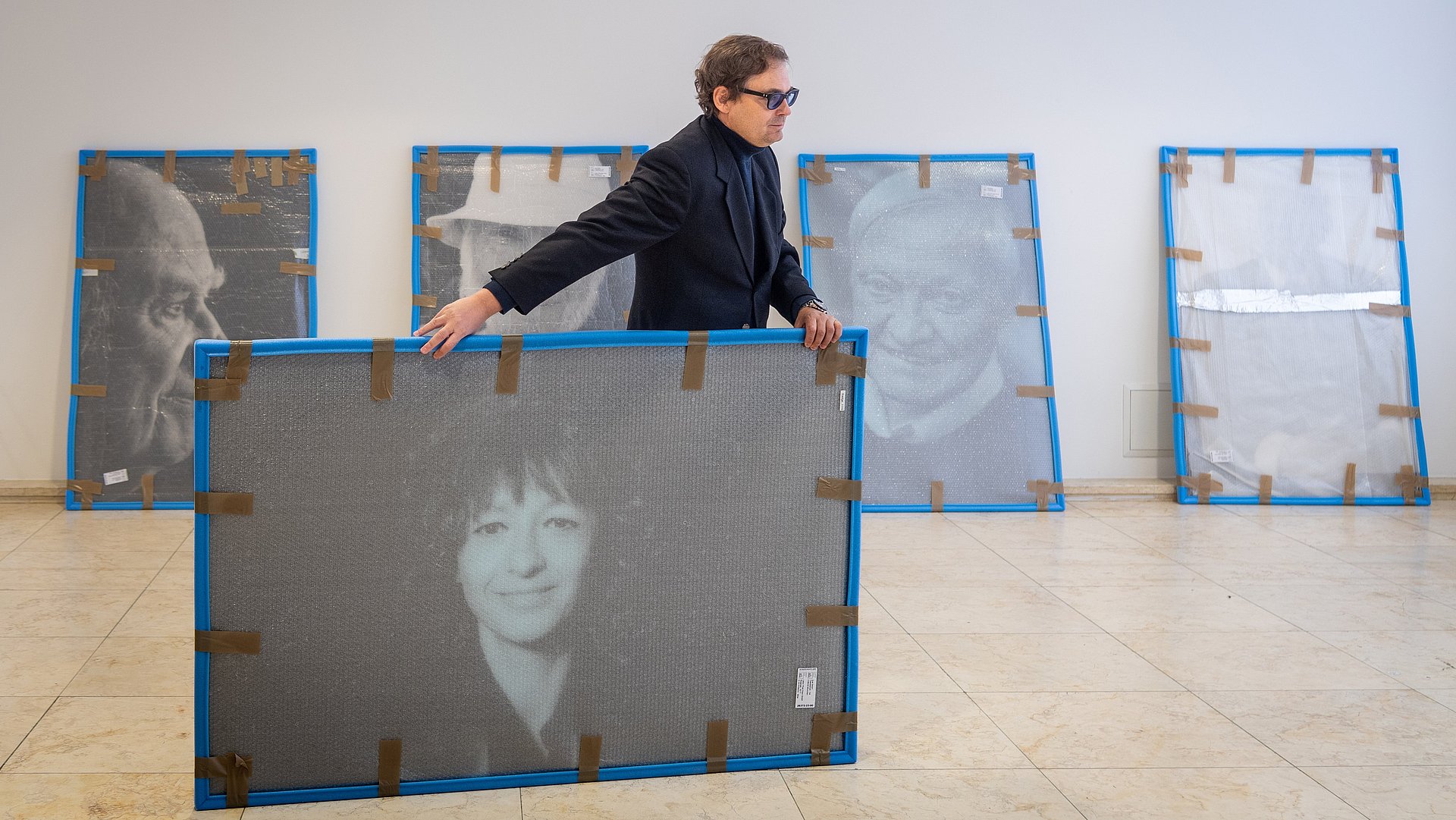 Fotograf Peter Badge beim Aufbau der Ausstellung Nobel Heros in der Imathalle mit Prof. Felix Mayer; Schwarz-Weiß Porträt der Nobelpreisträgerin für Chemie 2020, Emmanuelle Marie Charpentier 