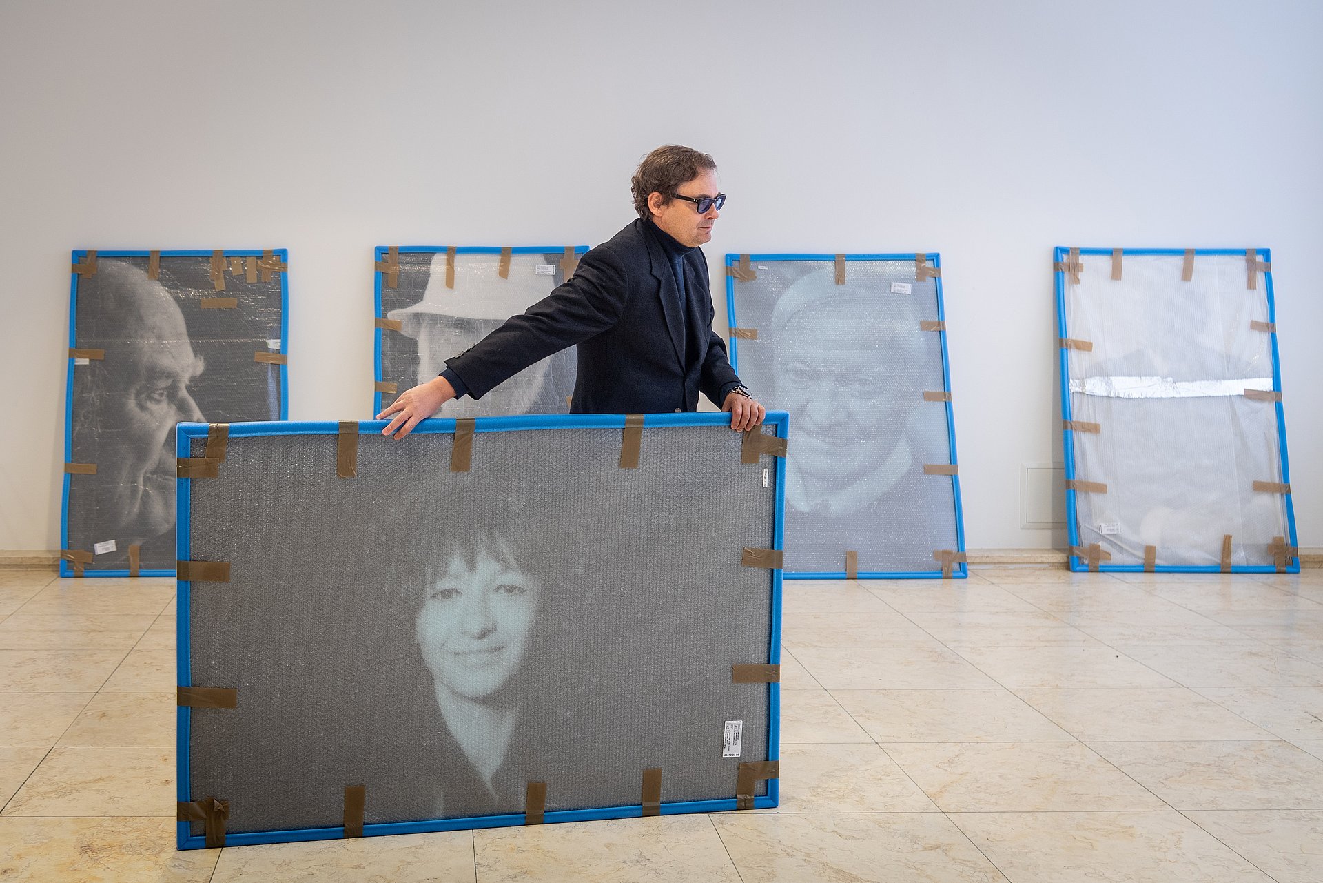 Fotograf Peter Badge beim Aufbau der Ausstellung Nobel Heros in der Imathalle mit Prof. Felix Mayer; Schwarz-Weiß Porträt der Nobelpreisträgerin für Chemie 2020, Emmanuelle Marie Charpentier 