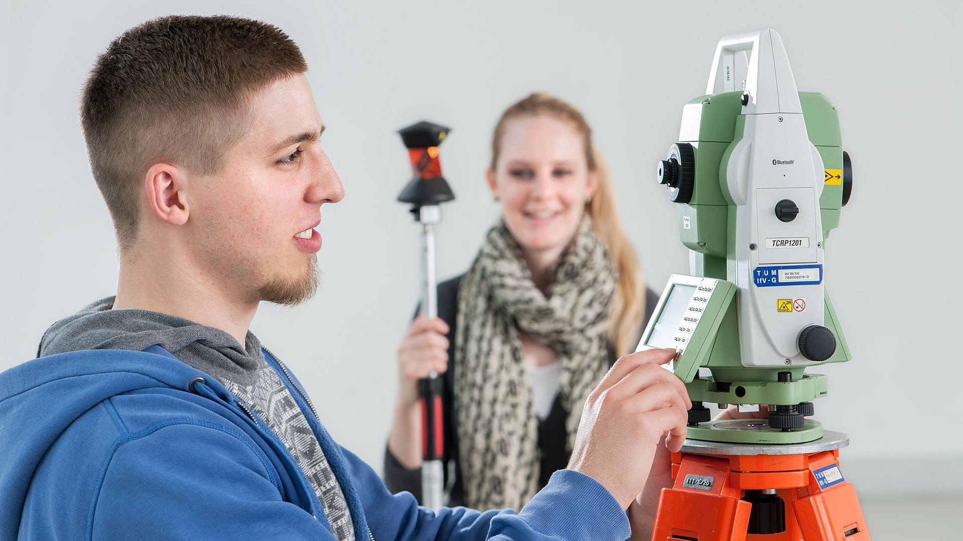 Two students working on a theodolite measuring device at the Chair of Cartography in 2013.