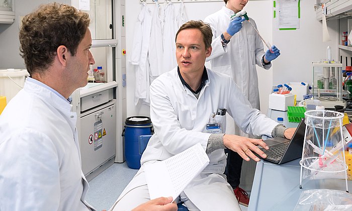 The authors of the study talking in a lab room.