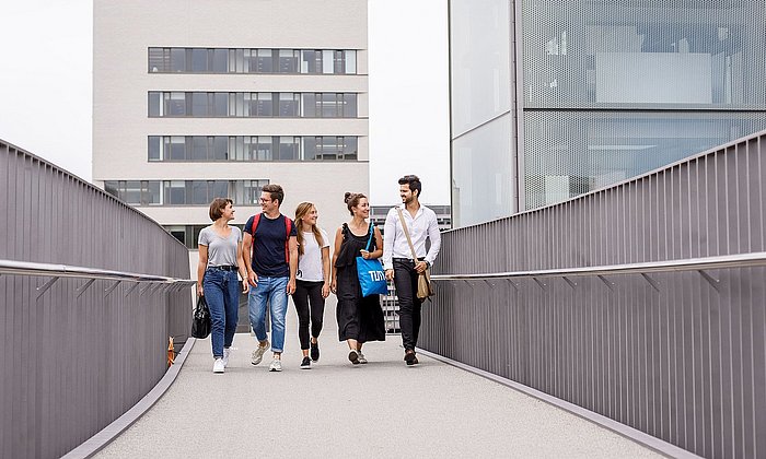 Studierende laufen über eine Brücke