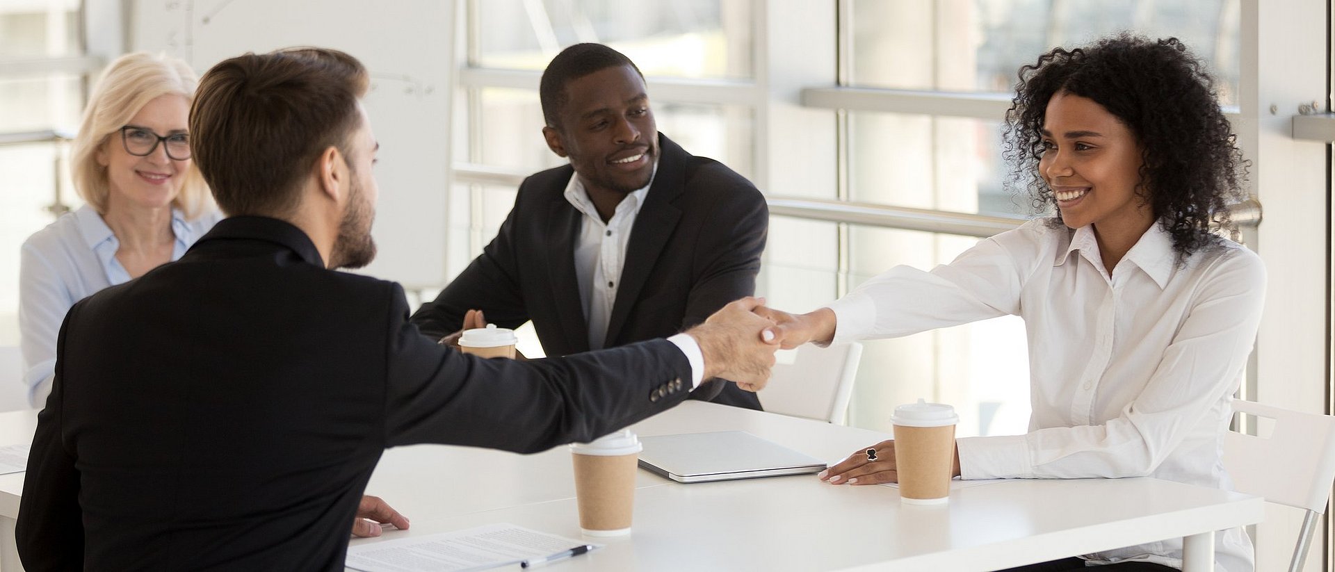 Business woman and man shake hands.