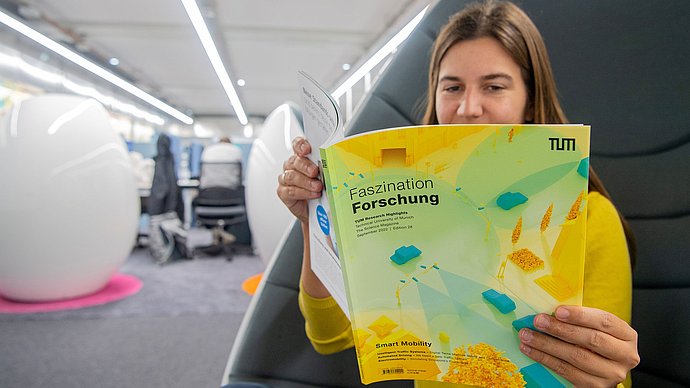 A person reads in the magazine "Faszination Forschung"