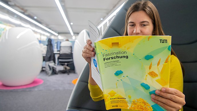A person reads in the magazine "Faszination Forschung"