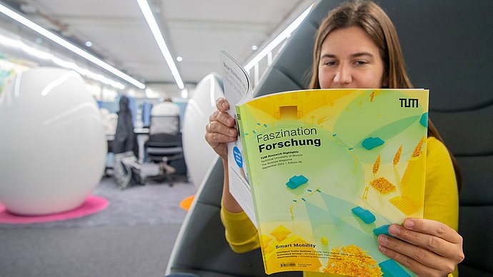 Eine Person liest im Magazin Faszination Forschung