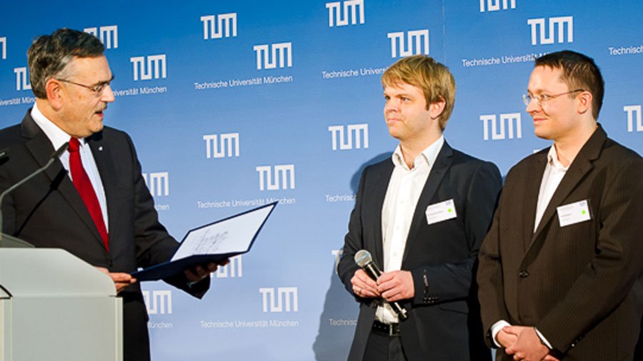 TUM-Präsident Herrmann zeichnet die fos4X-Gründer Thorbjörn Buck und Rolf Wojtech aus.
