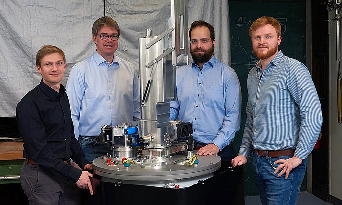 Alexander Regnat, Prof. Christian Pfleiderer, Jan Spallek und Tomek Schulz mit ihrem Kühlgerät für extrem tiefe Temperaturen.