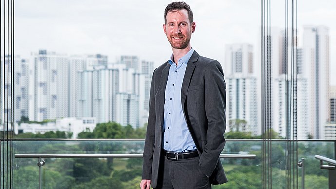 Dr. Stefan Klade, Forschungsdirektor bei TUMCREATE in Singapur Porträtaufnahme von Dr. Stefan Klade vor der Silhouette Singapurs