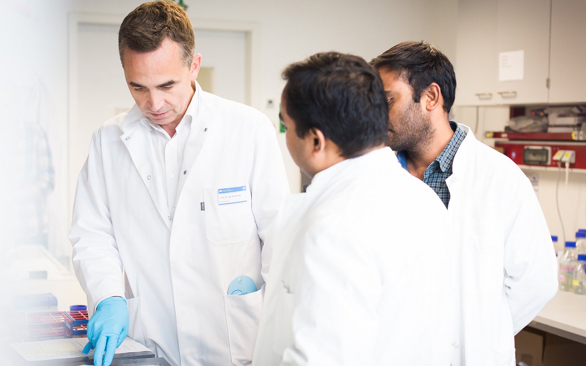 Mediziner Prof. Bernhard Hemmer mit zwei Mitarbeitern bei der Arbeit.