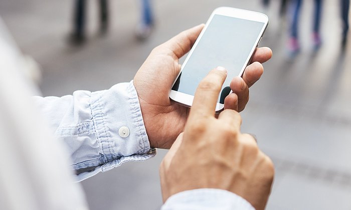 Eine Person schaut auf ihr Smartphone.