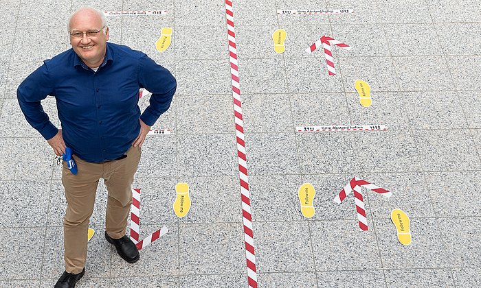 Prof. Klaus Bengler is standing in the hall of the department for machine engineering.