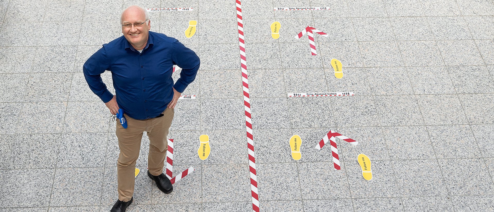 Prof. Klaus Bengler is standing in the hall of the department for machine engineering.