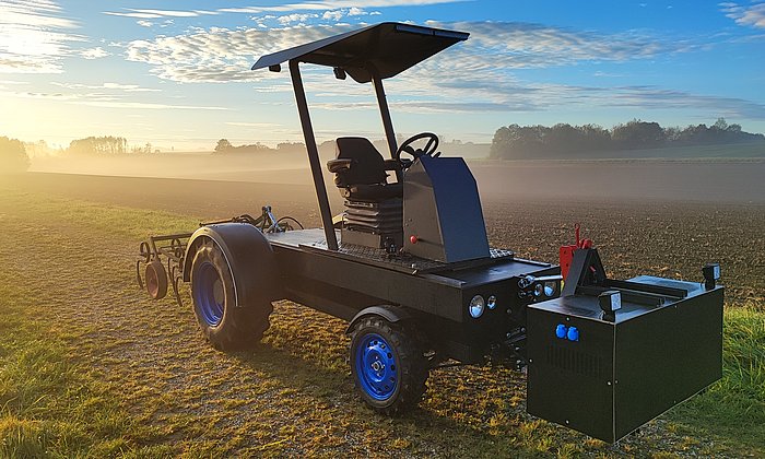 Ein modularer elektrischer Traktor steht auf einem Feld.