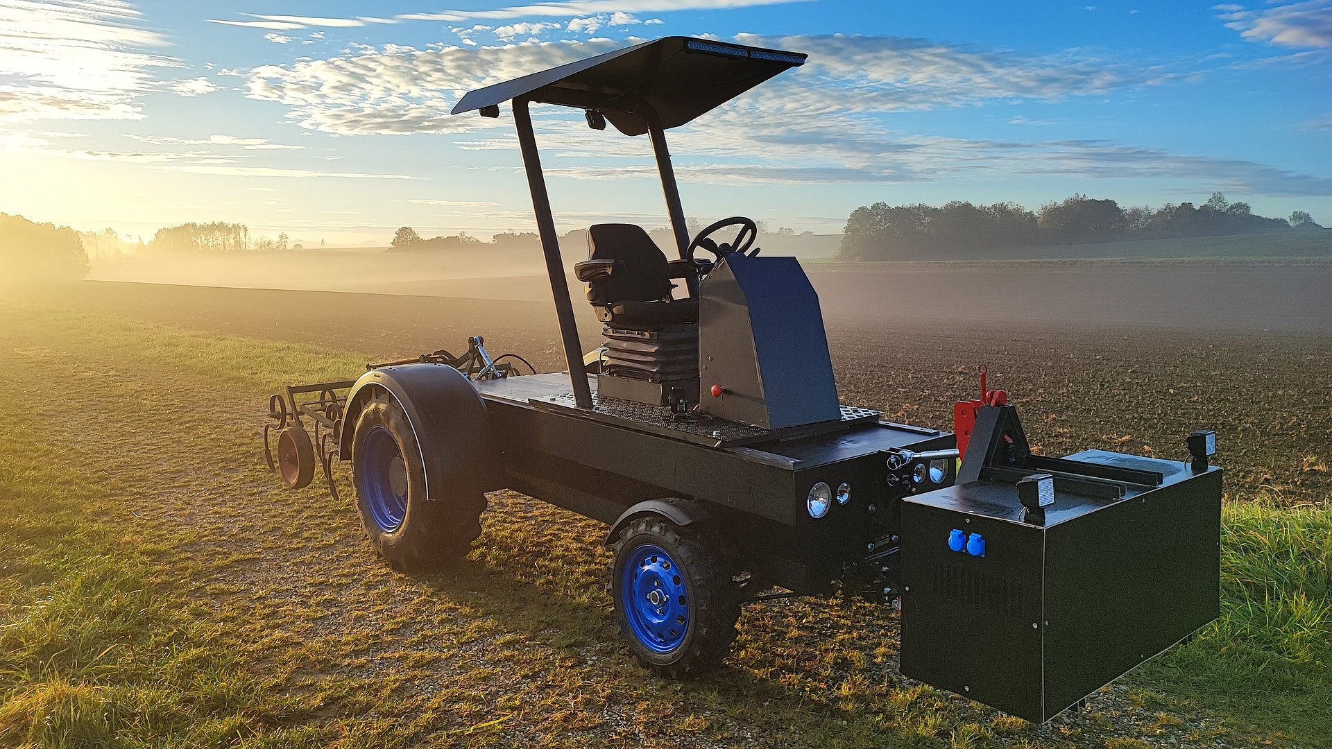 Ein modularer elektrischer Traktor steht auf einem Feld.