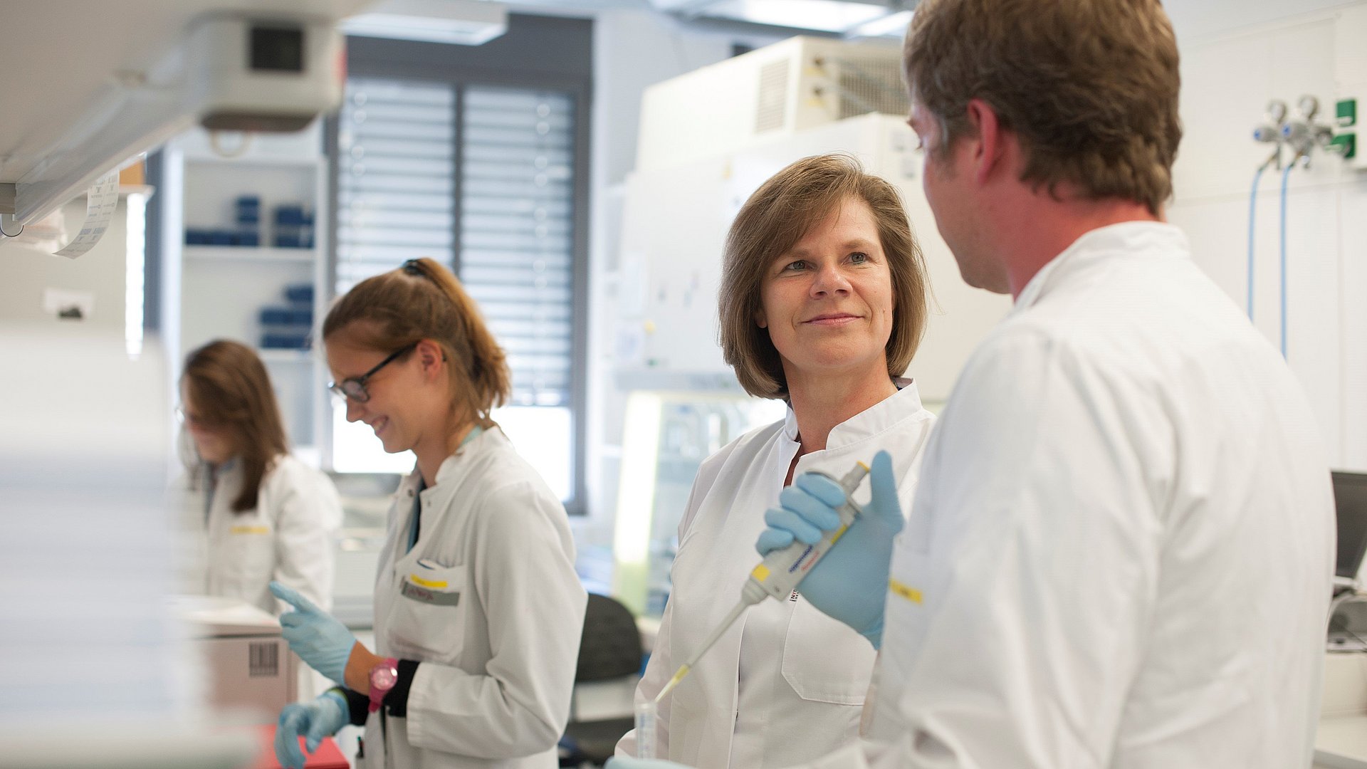 Prof. Ulrike Protzer, director of the TUM Institute of Virology, with staff members in the laboratory. 