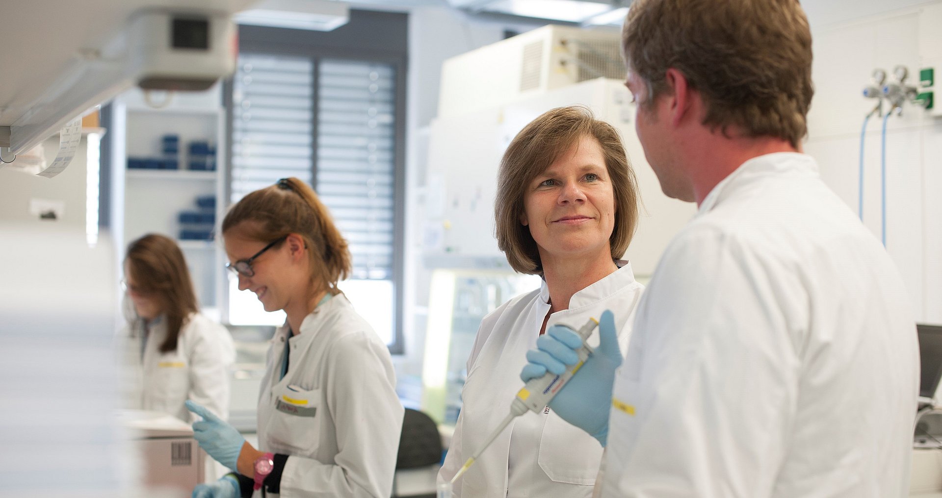 Prof. Ulrike Protzer, director of the TUM Institute of Virology, with staff members in the laboratory. 
