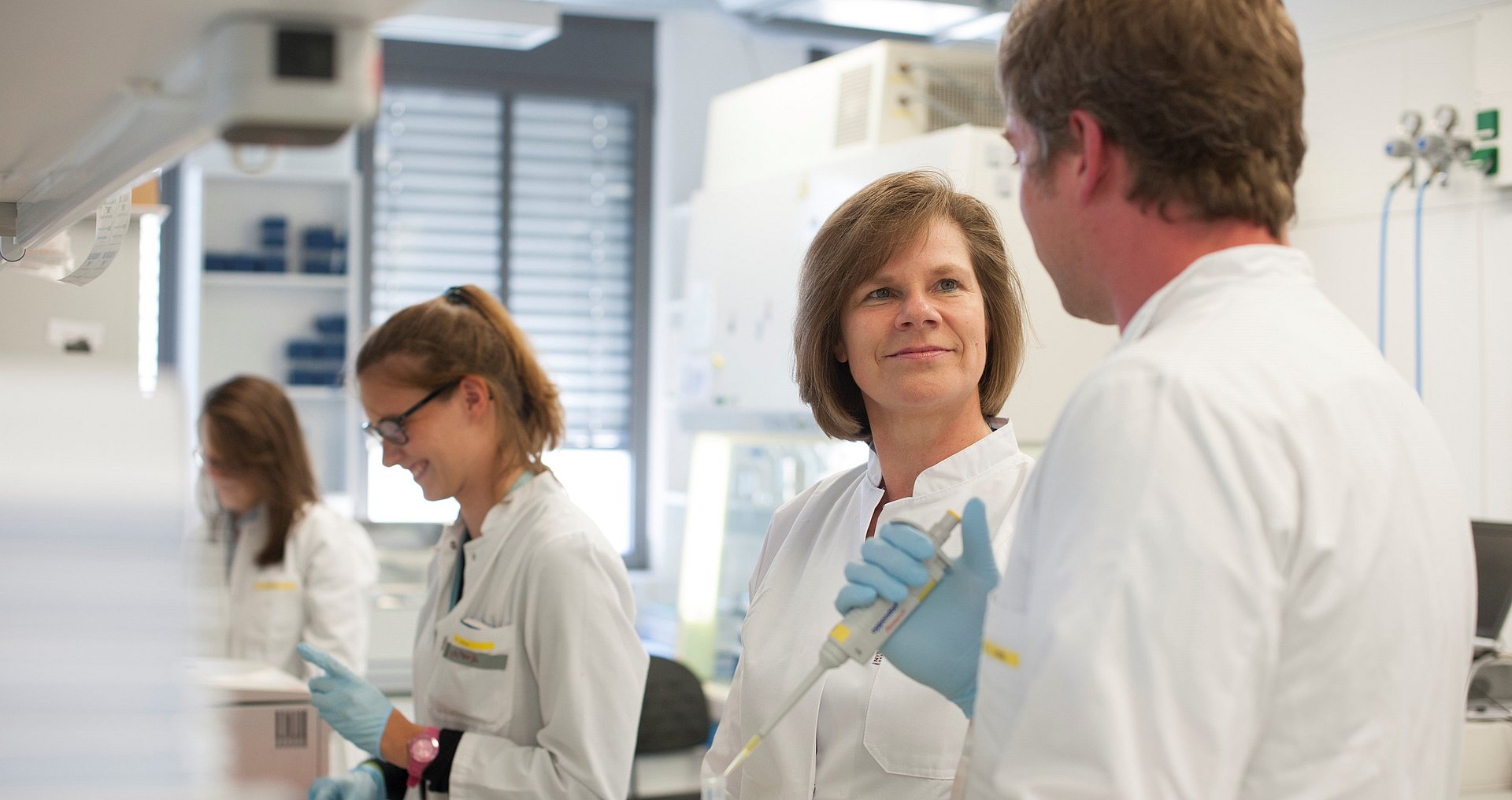 Prof. Ulrike Protzer, Direktorin des TUM Instituts für Virologie Ulrike Protzer, Direktorin des TUM Instituts für Virologie, mit Mitarbeiter:innen im Labor.