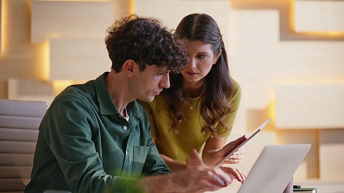 A man and a woman working on a computer