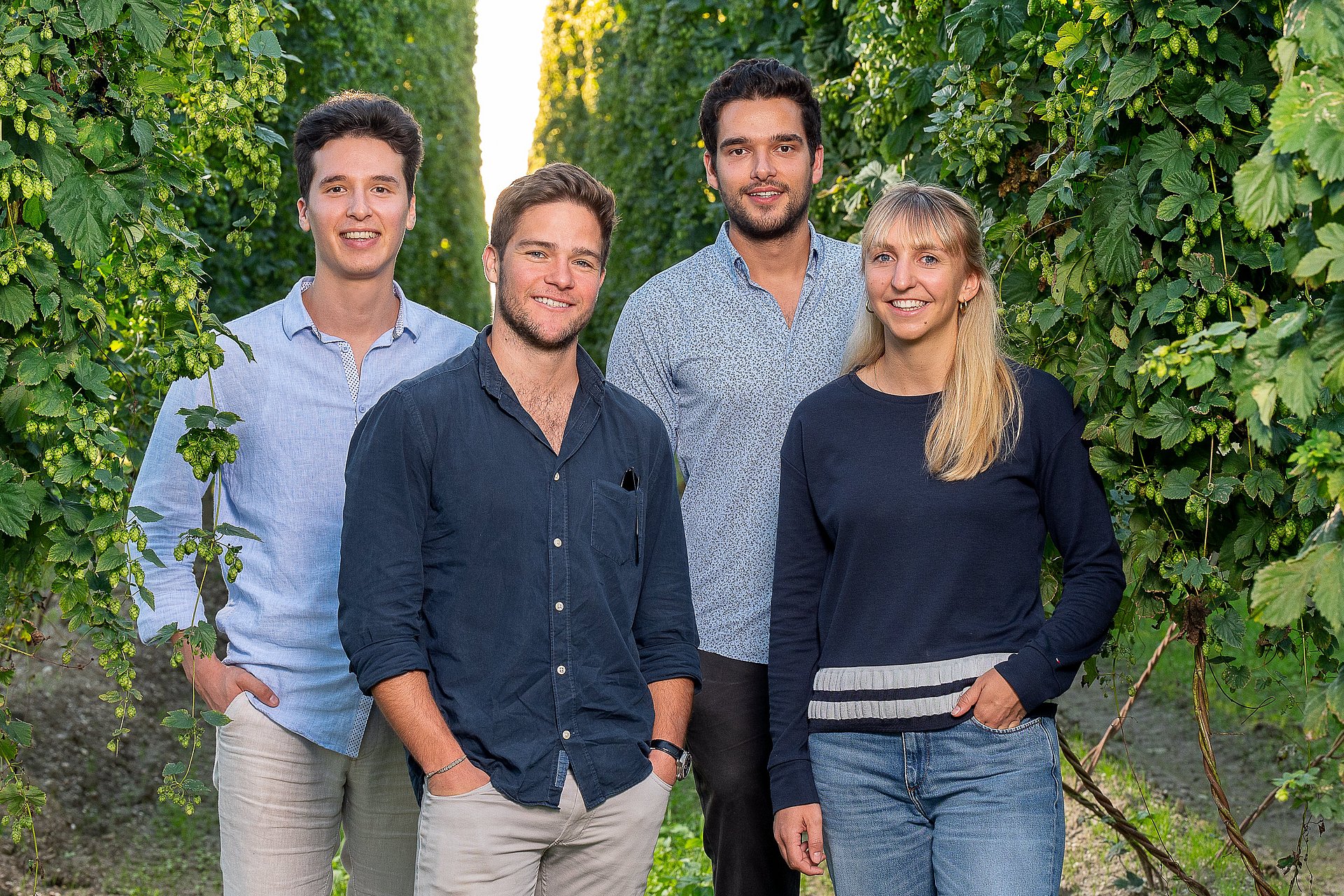The HopfON team stands between the hop vines in the field