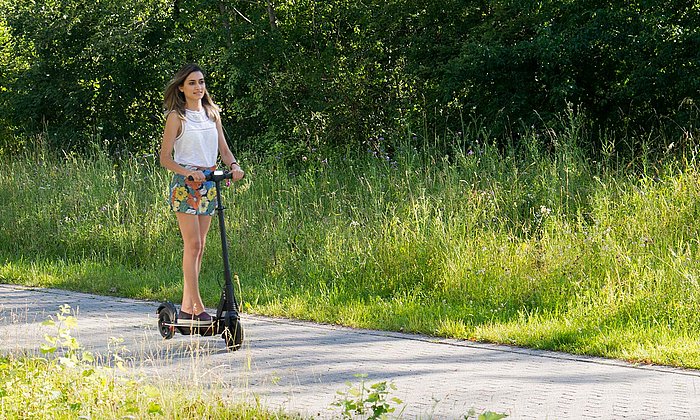 Pariya Shaigani, PhD candidate at the Werner Siemens Chair of Synthetic Biotechnology, on an e-scooter with a step made from a composite material integrating granite and carbon fibers from algae.