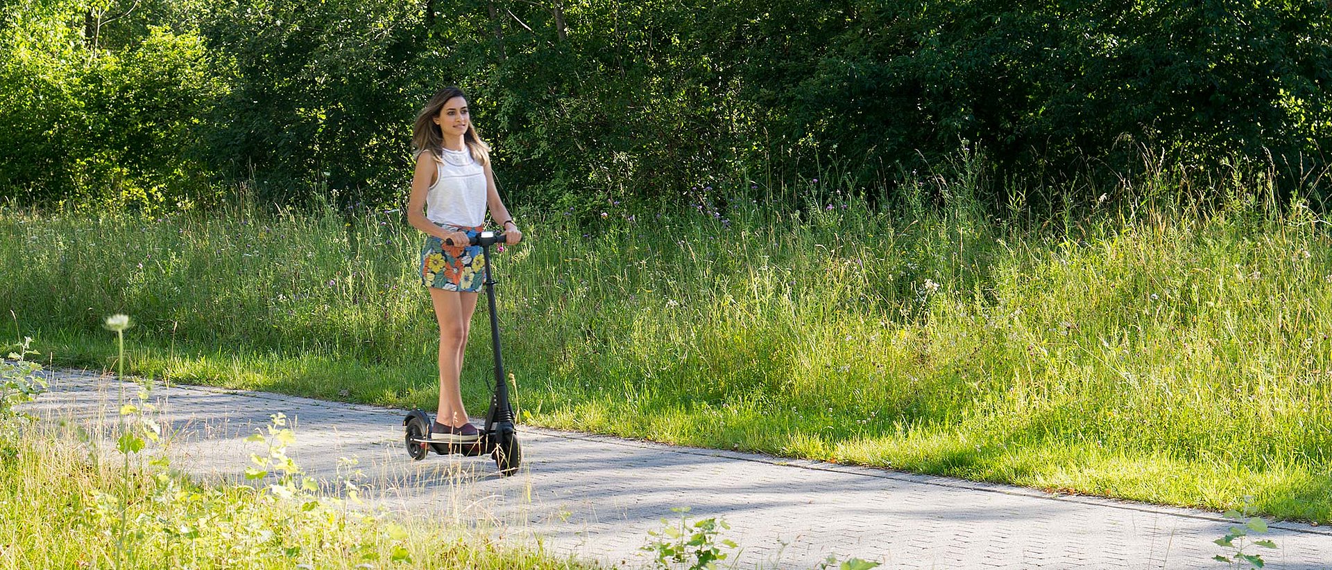 Pariya Shaigani, Doktorandin am Werner Siemens-Lehrstuhl für Synthetische Biotechnologie, auf einem e-Scooter mit Trittbrett aus einem Verbund von Granit und Carbonfasern aus Algen.