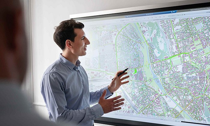 Male researcher presents something using a digital city map