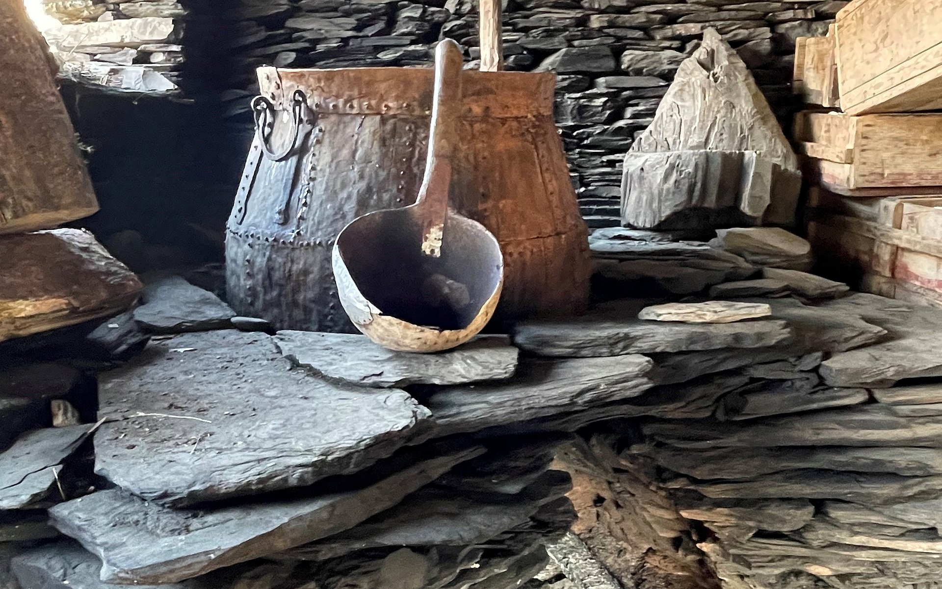 Ein alter Kupferkessel und Brauutensilien aus Holz.