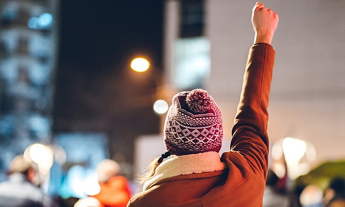 A woman raises her fist during a demonstration.