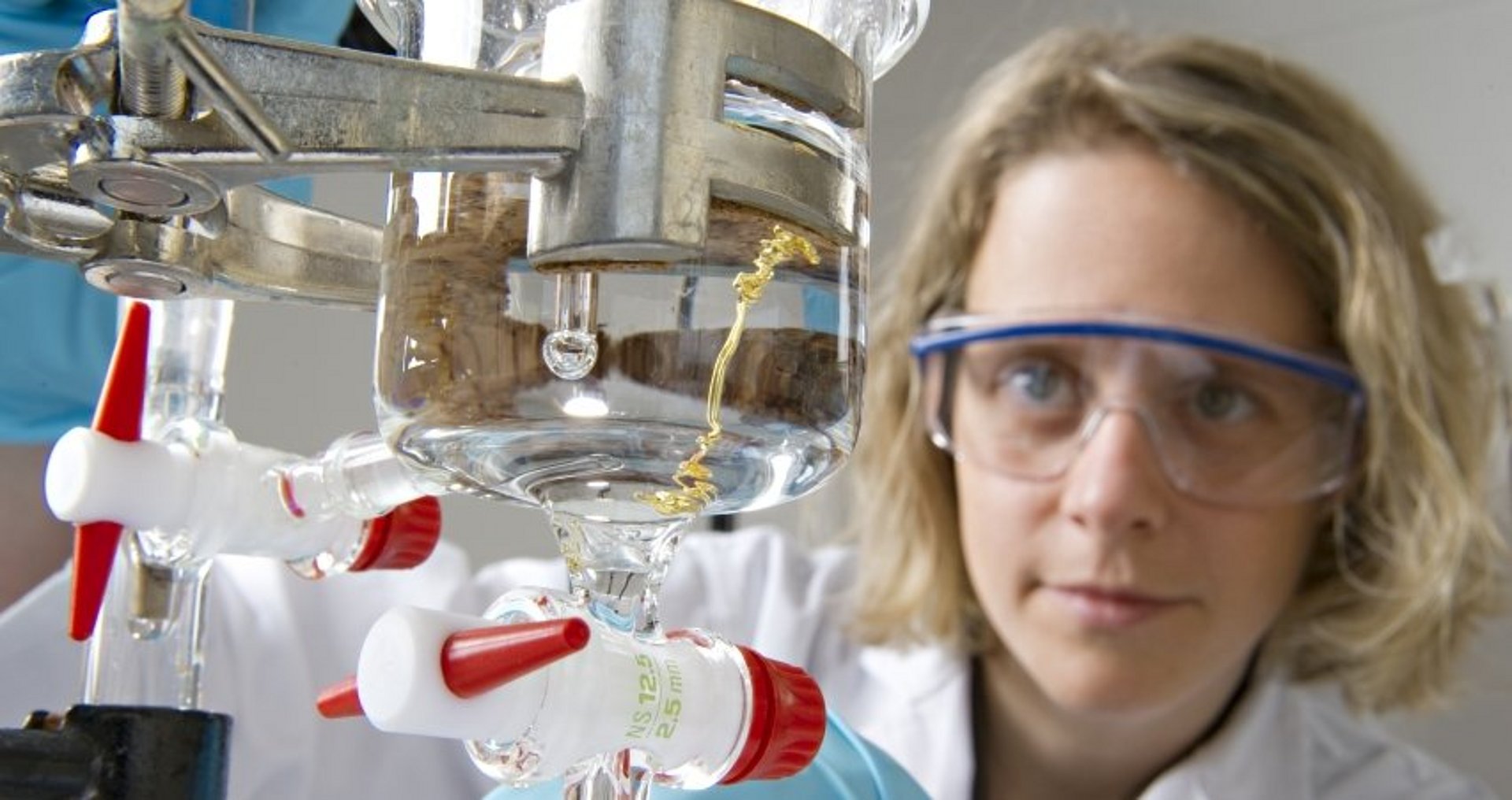 Chemikerin mit Schutzbrille an einem Experiment im Labor.