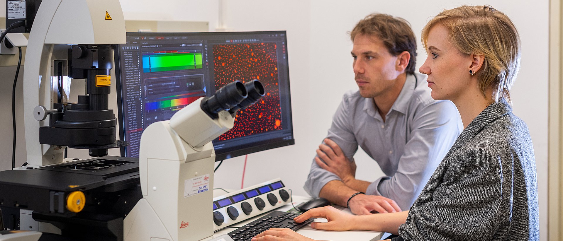 Prof. Job Boekhoven and Caren Wanzke discovered a new material system that can release drugs with a constant release rate over a tunable period of time. The microscopic image (right screen) shows droplets of the hydrolyzable oil-emulsion embedded in a hydrogel. 