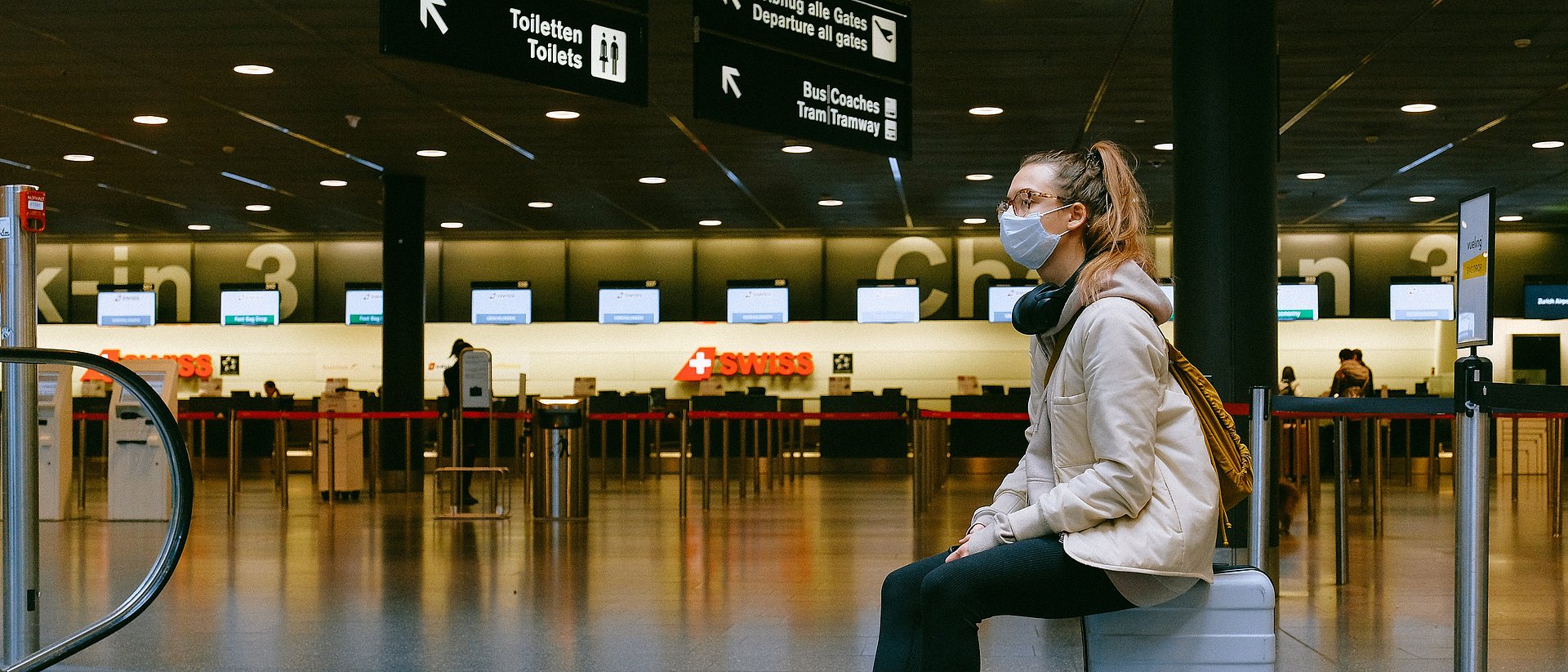 Woman with mouth-nose protection in empty airport terminal Woman with mouth-nose protection in empty airport terminal