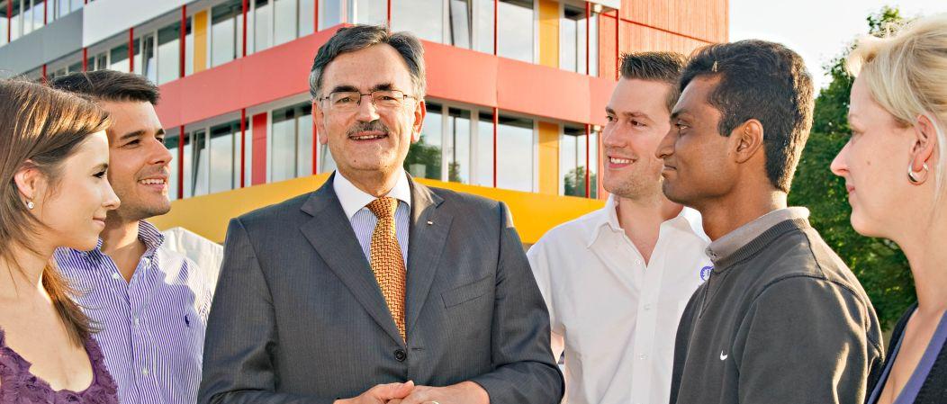 Der Präsident der TUM, Prof. Wolfgang A. Herrmann, mit Doktoranden vor dem Exzellenzzentrum in Garching Der Präsident der TUM, Prof. Wolfgang A. Herrmann, mit Doktoranden vor dem Exzellenzzentrum in Garching