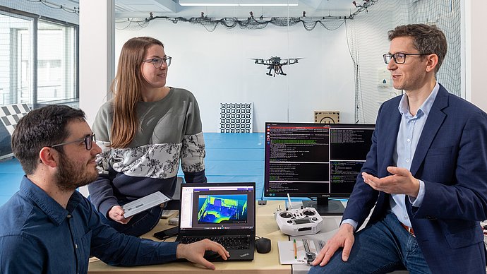 Forschende arbeiten in einem Labor mit einer Drohne.