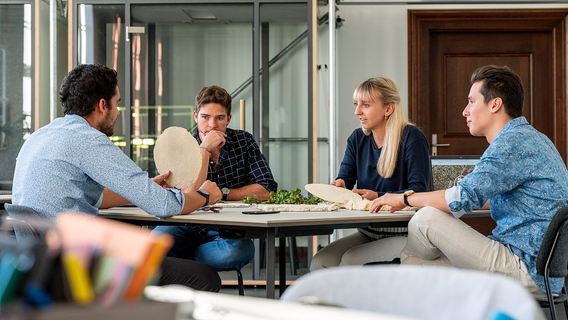 Das Team von HophON sitzt am Tisch und diskutiert