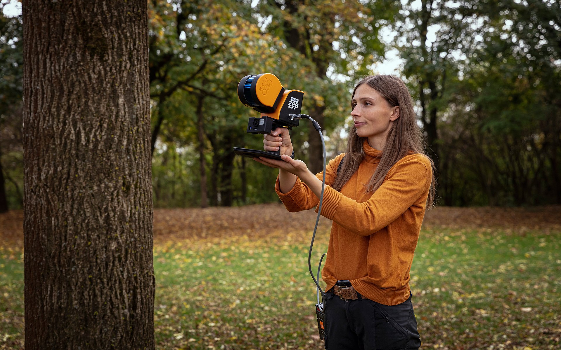 Sophie Arzberger uses the hand-held 3D laser scanner to record the vegetation structure around one of the climate stations.