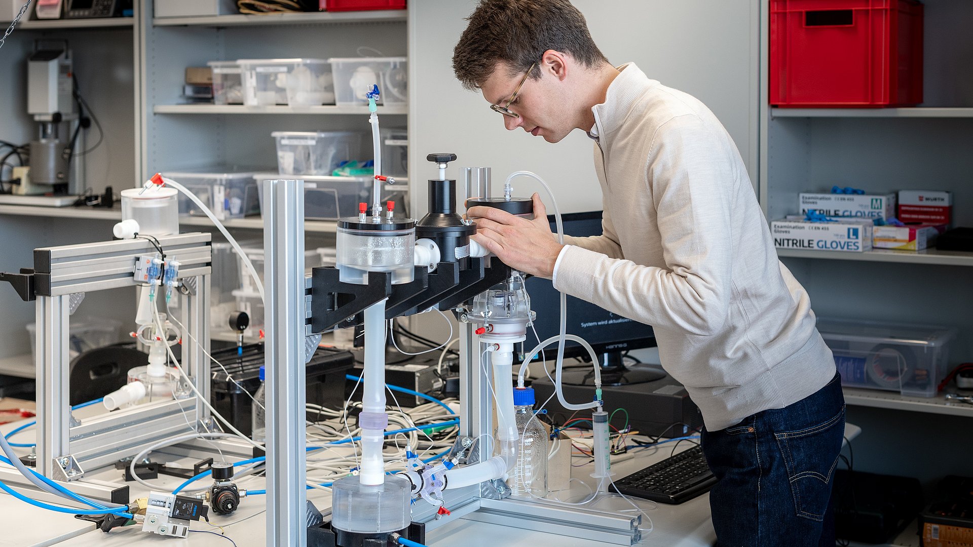 Kilian Mueller, Doktorand an der TUM School of Engineering and Design, prüft in einem Testlauf die Funktionalität einer 3D gedruckten Herzklappe in einem Mock-up Blutkreislauf-System, das die Blutzirkulation simuliert. 